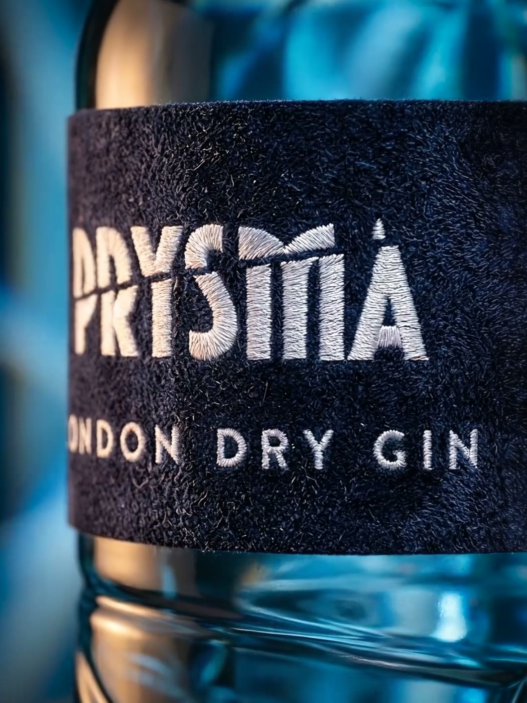 Bottiglia Prysma London Dry Gin illuminata da fasci di luce